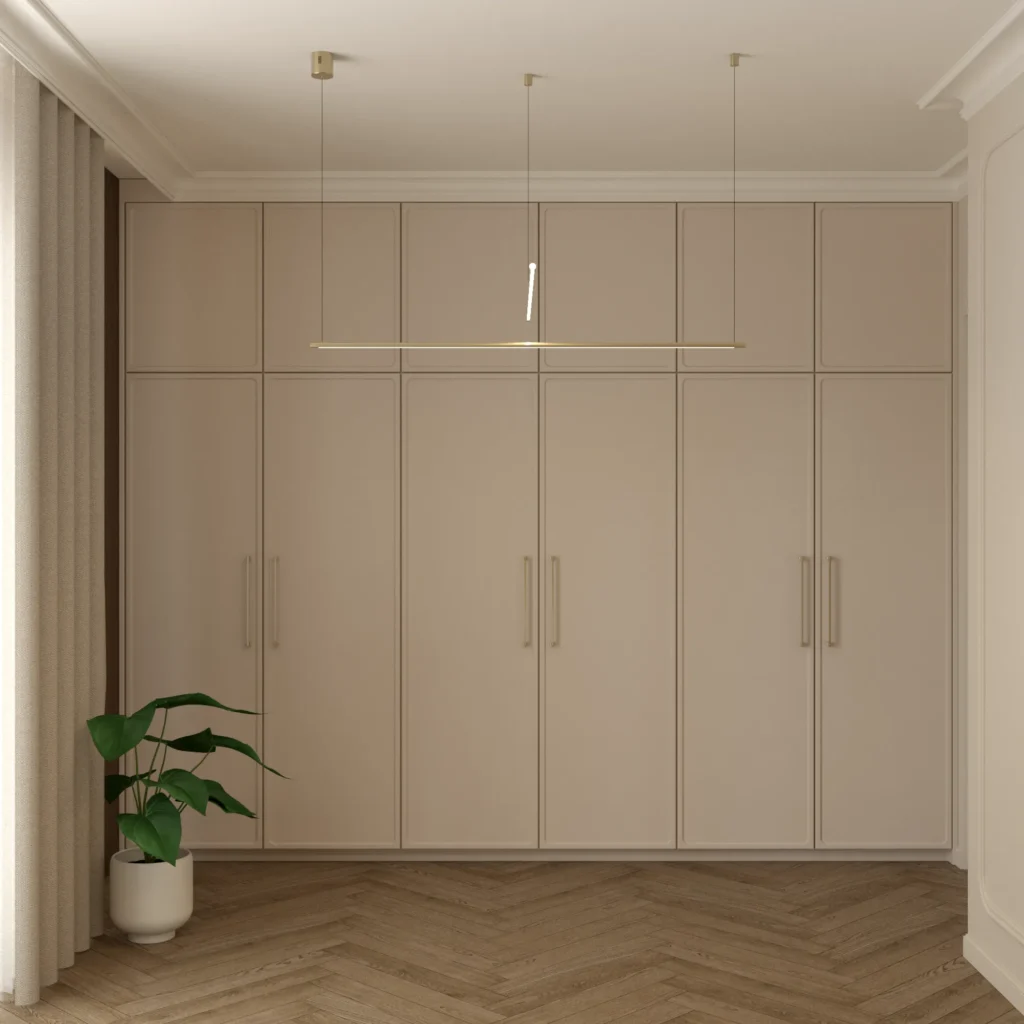 Beżowa szafa z frezowanymi frontami, złotymi uchwytami i dekoracyjną lampą w eleganckiej sypialni.